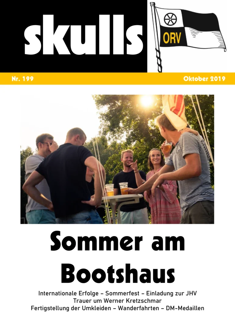 Fünf Personen lachen und unterhalten sich an einem Stehtisch im Freien bei sonnigem Wetter.